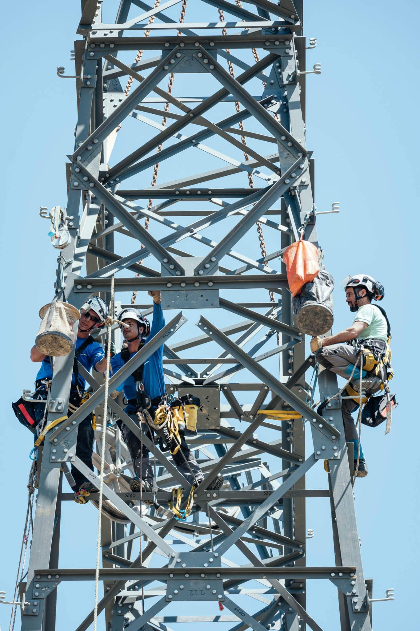photo d'ouvriers attachés à un pylône électrique de haute tension