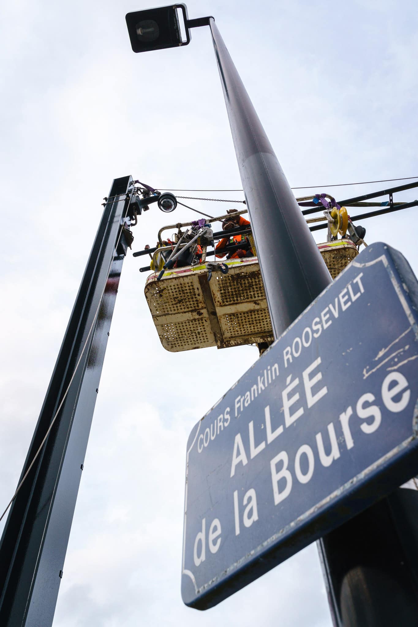 Des ouvriers travaillent depuis leur nacelle à la réhabilitation de la ligne de tram dans le centre ville de Nantes